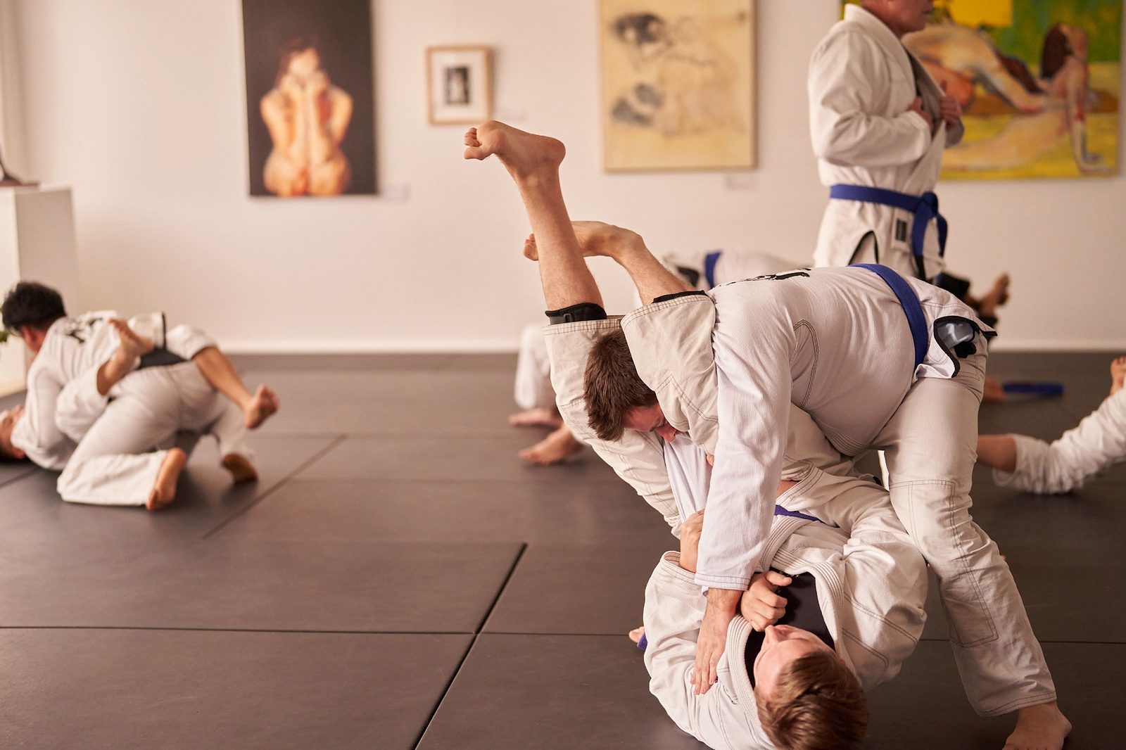 Students grapple from standing during a sparring round.