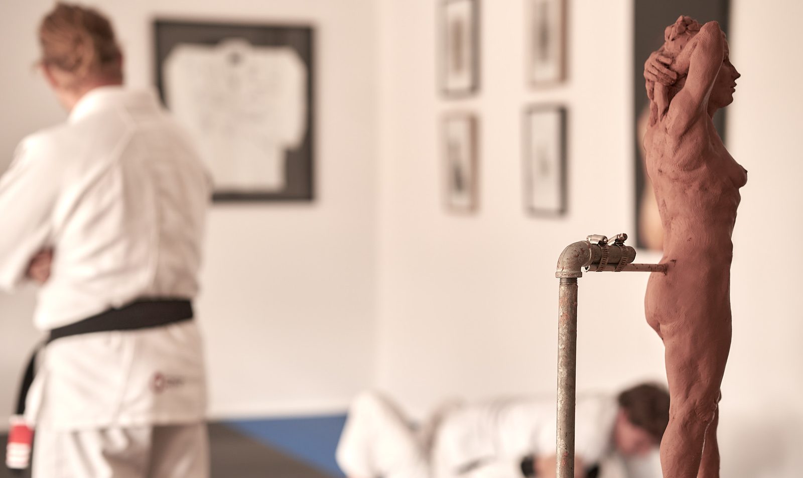 The training space with framed artwork on the walls and a sculpture on a stand.