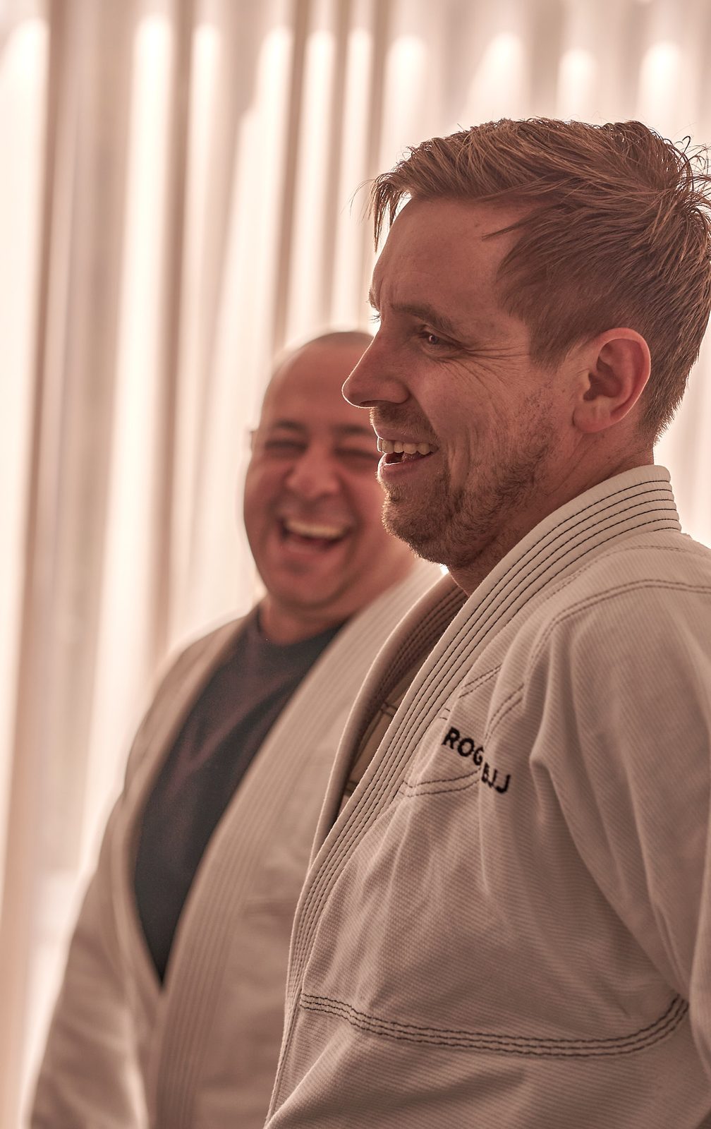 Two members share a laugh on the mats after a round.